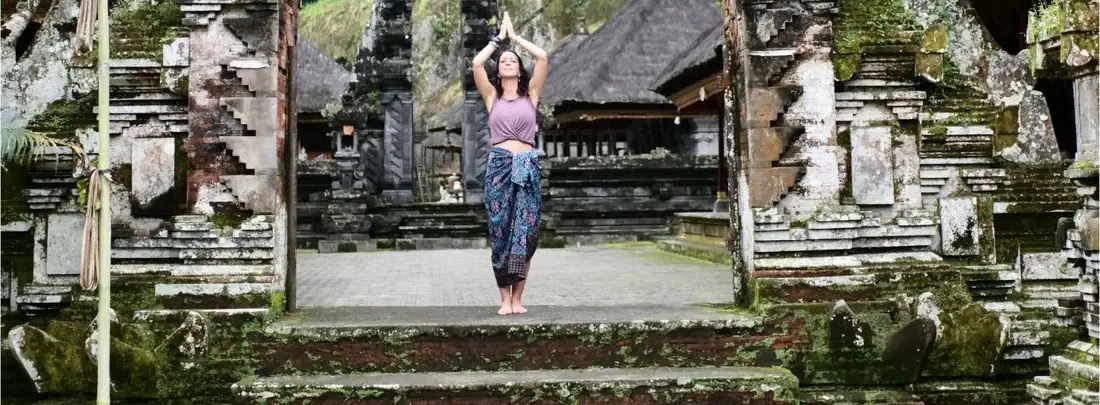 Alexandra Berna bras levés au seuil d'un temple à Bali