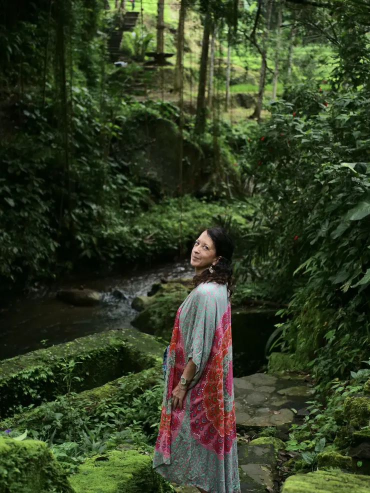 Alexandra en kaftan multicolore, se retournant dans la nature balinaise