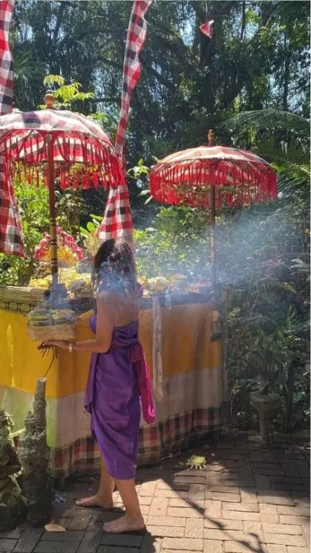 Alexandra en offrande, parasols traditionnels balinais