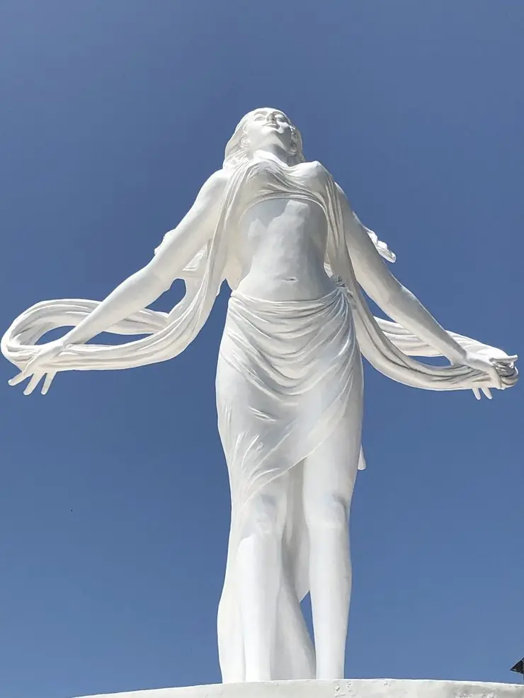 Reconnexion au féminin — bras ouverts vers le ciel, drapé en mouvement